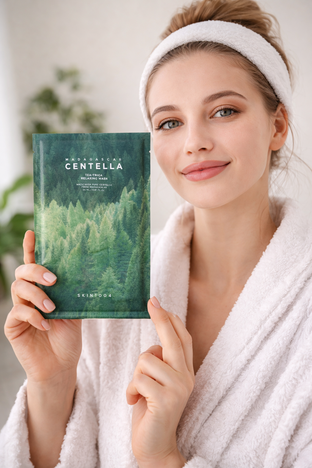 Woman holding a Madagascar Centella Tea-Trica Mask product with a forest design packaging