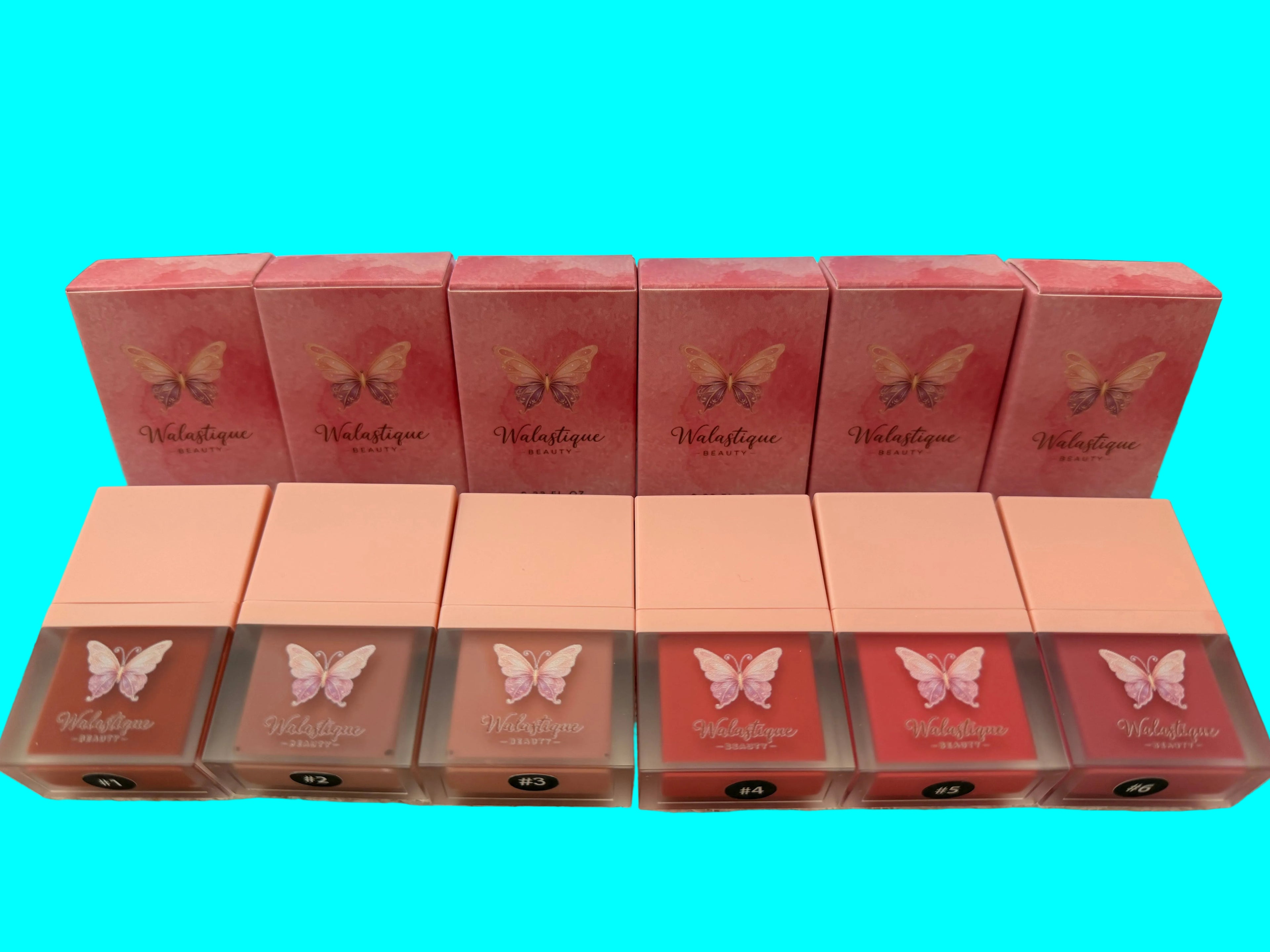 Multiple boxes of a Walastique Beauty liquid blush with butterfly design on a light blue background.