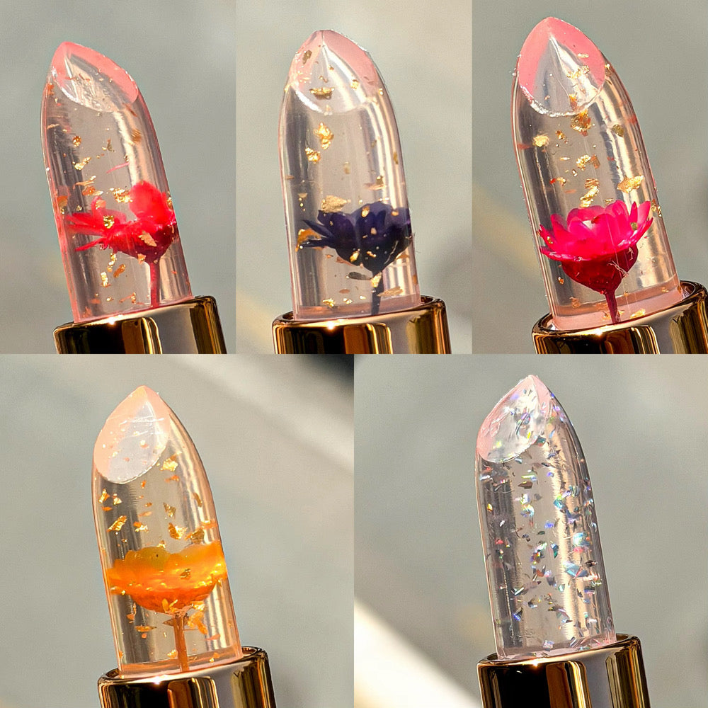 Collage of five lipstick with floral and glittery designs on a gray background