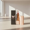 Walastique Beauty floral lipstick and packaging on a reflective surface.