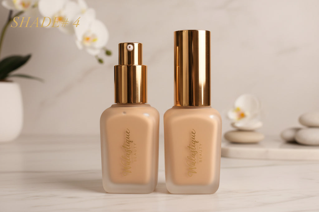 Two Walastique foundation bottles with gold caps on a textured surface.